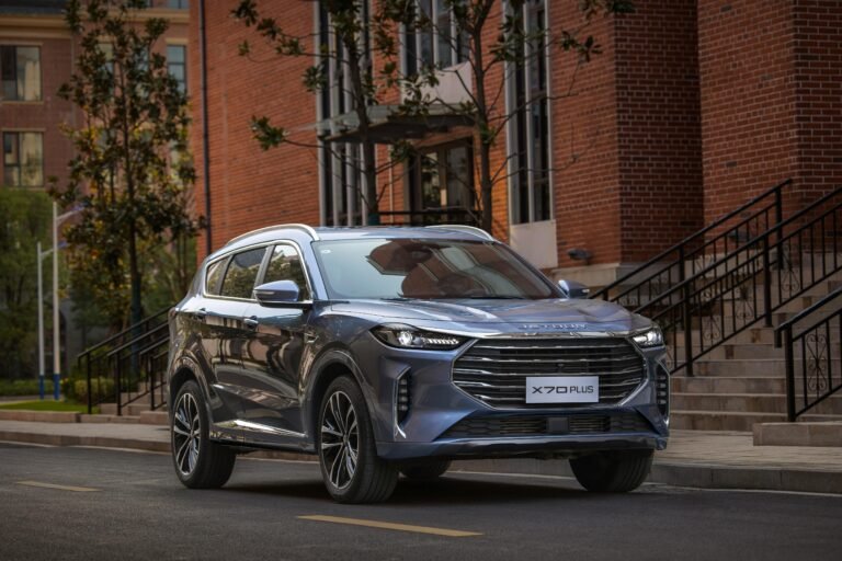 A sleek blue SUV parked on a city street, showcasing its modern design against a brick building.