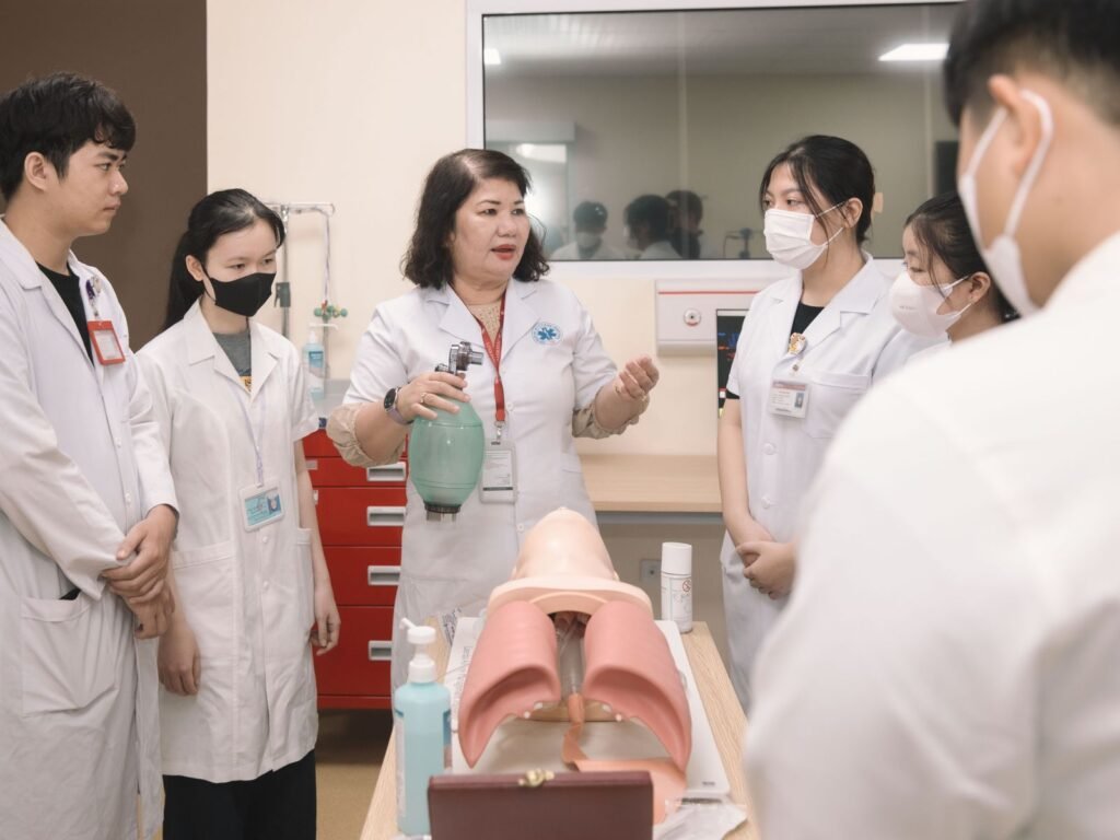 Medical students practicing clinical skills with a training mannequin.