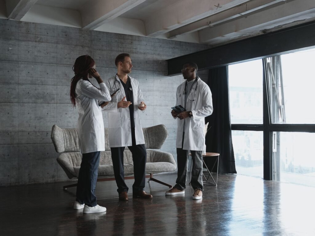 Three physicians discussing residency options in a modern clinical workspace.