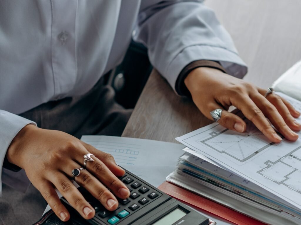 A finance professional working with a calculator and financial documents.