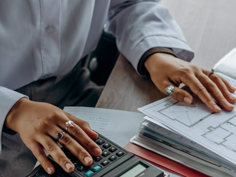 A finance professional working with a calculator and financial documents.