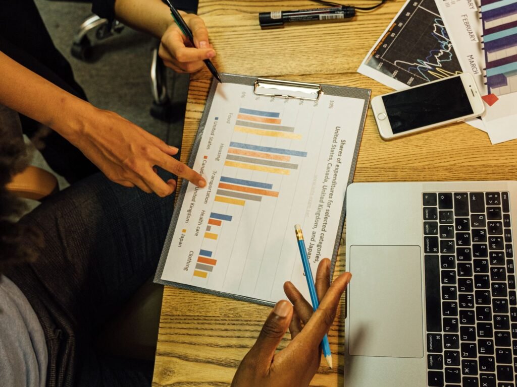 Colleagues reviewing printed charts and reports around a table.