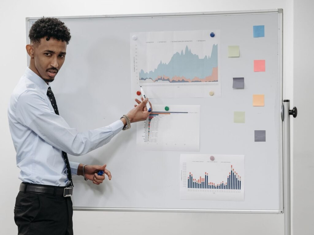 A presenter discussing charts with colleagues in an office.