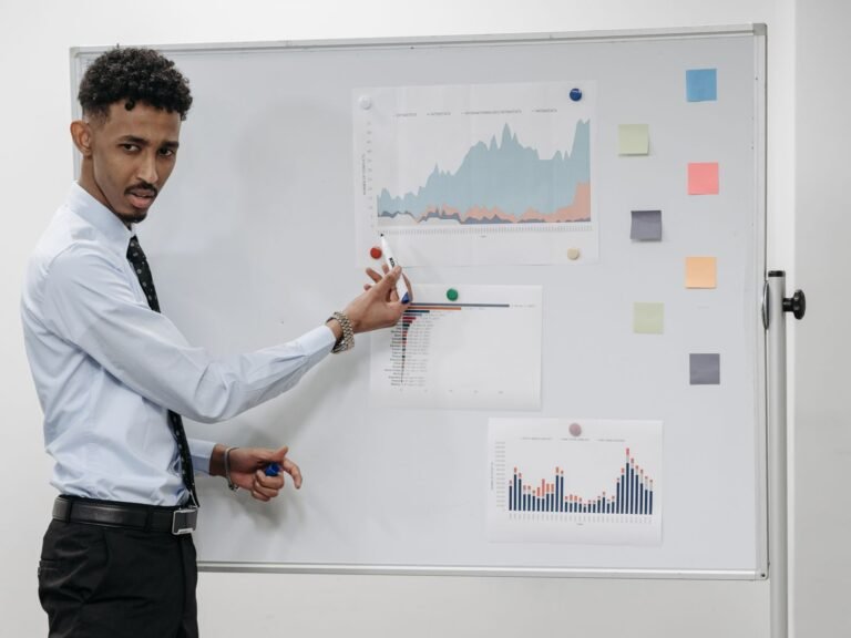 A presenter discussing charts with colleagues in an office.